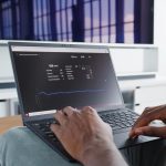 a person sitting in front of a laptop computer dashboard analytics graphs subscription revenue chart laptop screen