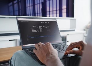 a person sitting in front of a laptop computer dashboard analytics graphs subscription revenue chart laptop screen
