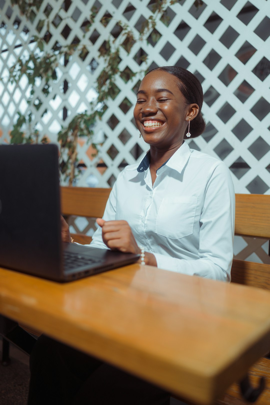 A smiling woman works on her laptop outdoors. happy customer using laptop credit card online subscription payment