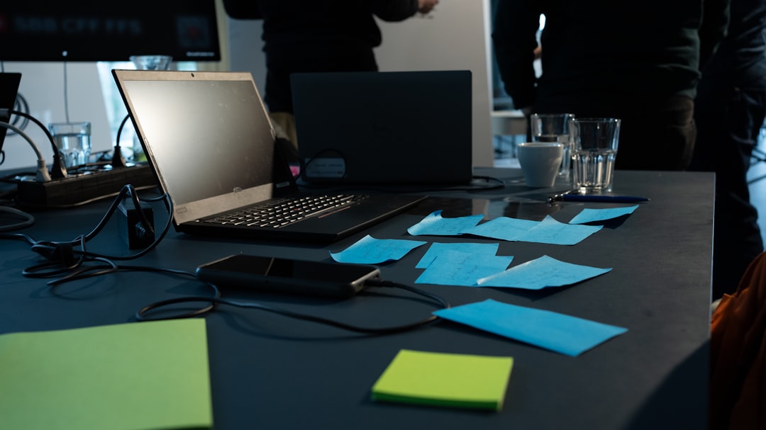 a table with sticky notes and a laptop on it cybersecurity team meeting, digital evidence review, incident response planning