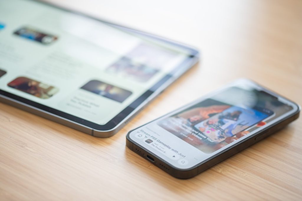 A tablet and smartphone displaying content on a wooden table multiple devices, shared document, sync conflict