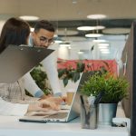 Colleagues collaborating in a modern office environment. diverse tech team meeting, laptops collaboration, modern office workspace, software development discussion