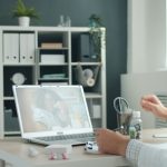 Doctor consulting patient online via laptop computer. doctor video call laptop, patient at home, telemedicine app interface