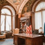 Elegant office with american flag and presidential desk. law office desk, laptop with legal software, digital documents screen