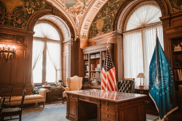 Elegant office with american flag and presidential desk. law office desk, laptop with legal software, digital documents screen