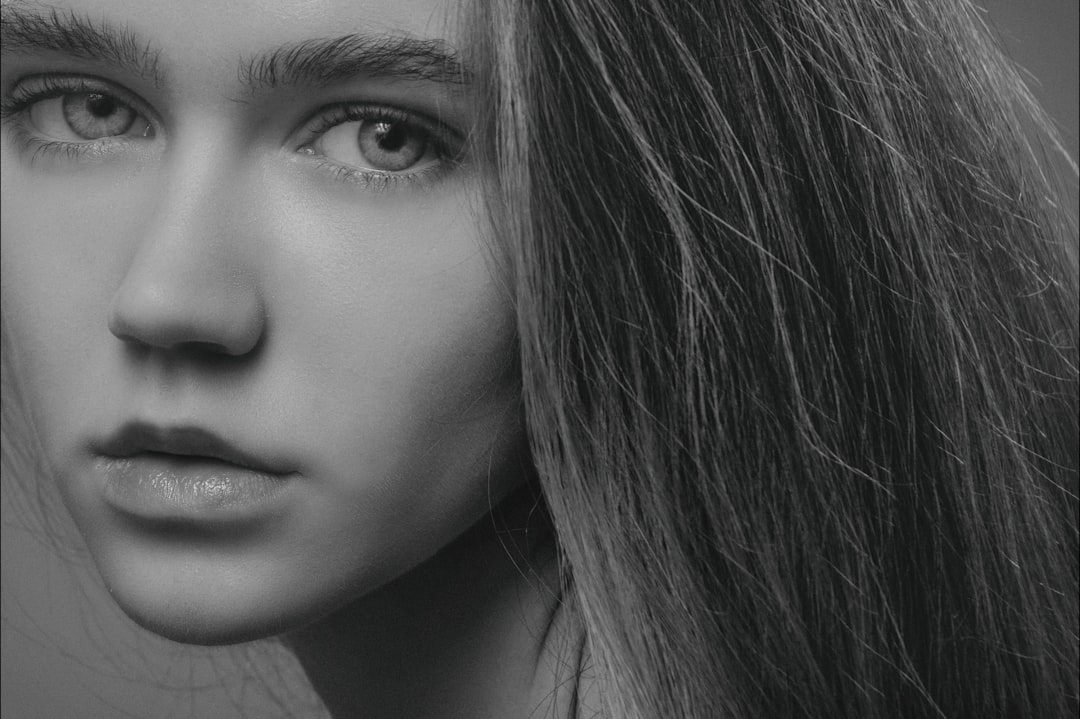 grayscale photography of long-haired woman designer using pen tool, image masking process, zoomed hair selection detail