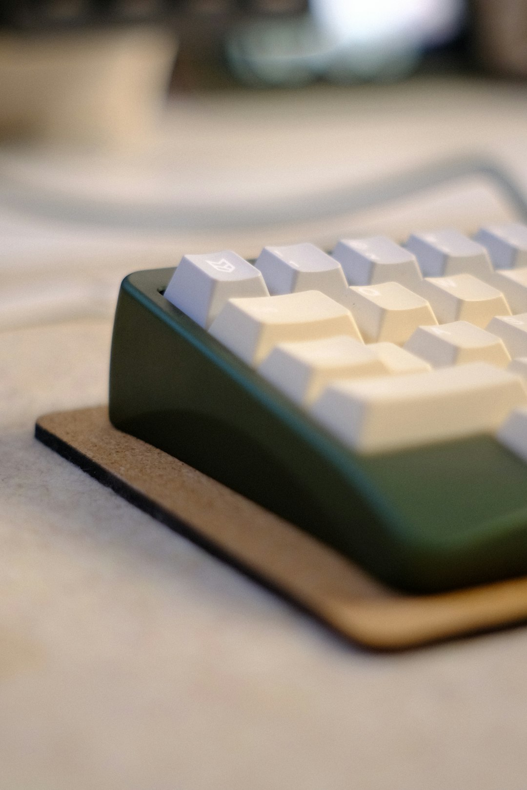 Green mechanical keyboard with white keycaps on a brown mat. custom mechanical keyboard close up, thick pbt keycaps, artisan keycap, desk mat