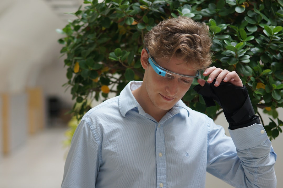 man in blue dress shirt wearing blue framed eyeglasses smart glasses display overlay, augmented reality instructions, industrial worker hands free