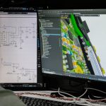 Man looking at circuit board design on computer screen. architect using 3D modeling software, house design model, digital blueprint on screen