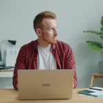 Man working on laptop at desk in office person working from home, laptop healthcare coding, home office workspace, relaxed professional