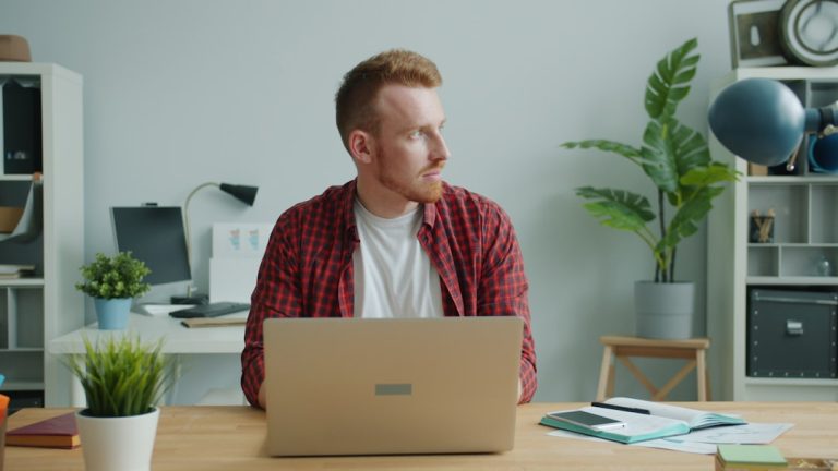 Man working on laptop at desk in office person working from home, laptop healthcare coding, home office workspace, relaxed professional