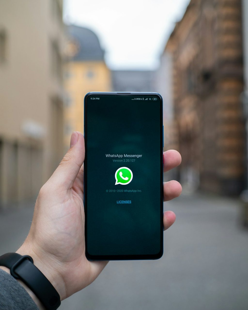 person holding black android smartphone smartphone whatsapp verification screen, sms code, mobile app interface