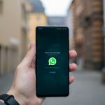 person holding black android smartphone smartphone whatsapp verification screen, sms code, mobile app interface