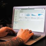 person using macbook pro on table data team, workshop session, laptop dashboards