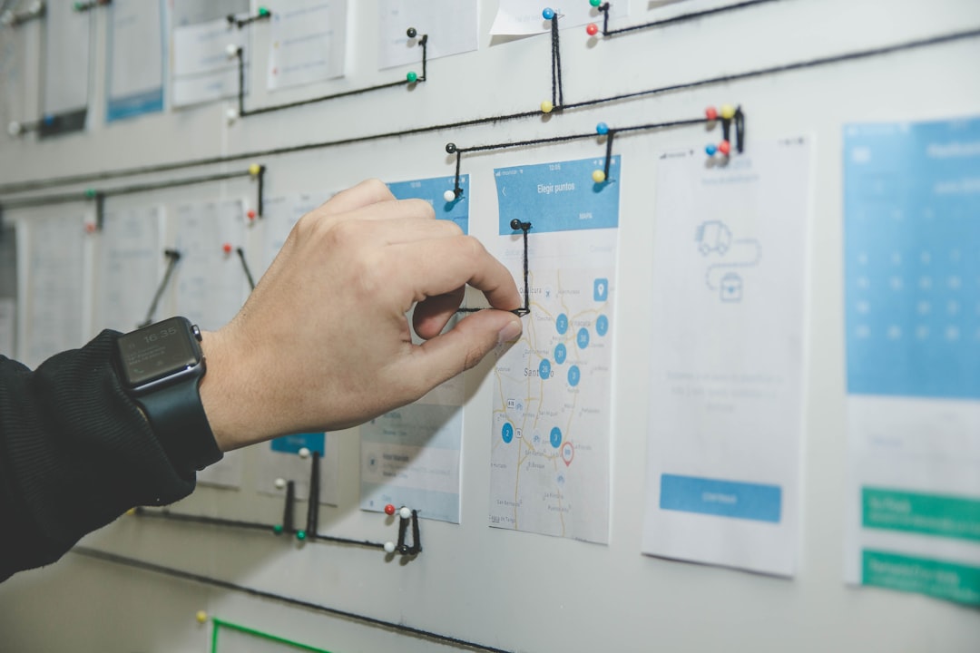 person working on blue and white paper on board technology planning, connected systems, business workflow