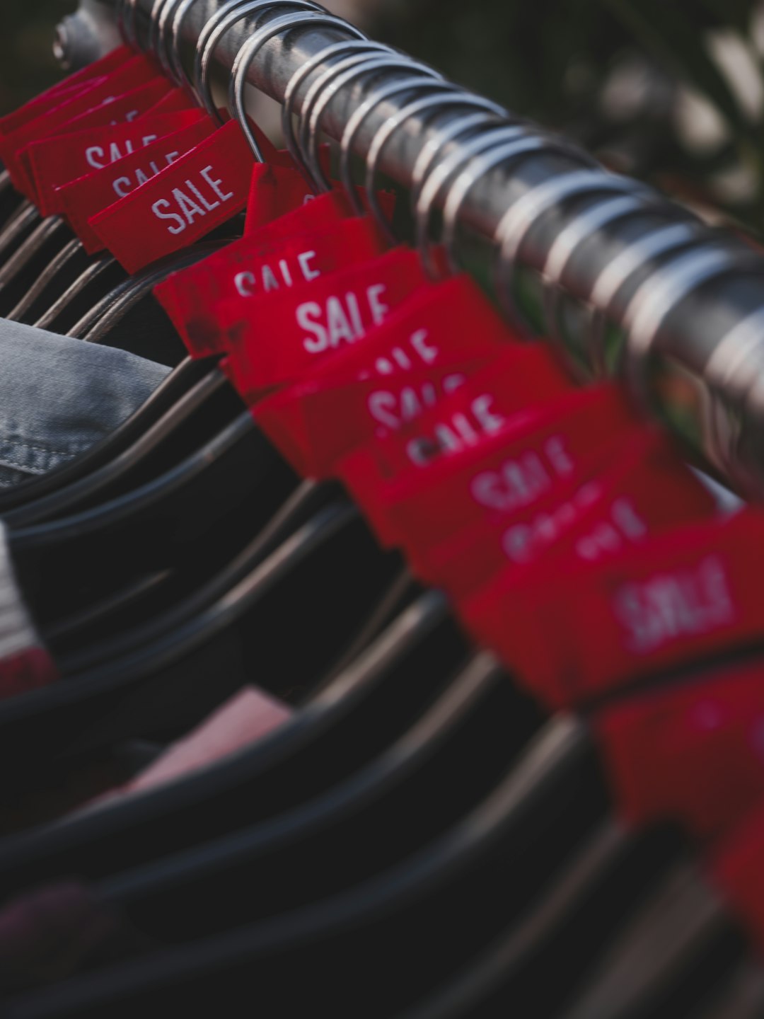 Red sale tags hanging on a clothing rack brand labels, messy spreadsheet, data cleaning