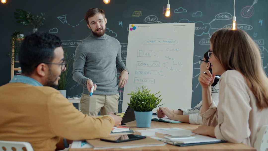 Team collaborating around a whiteboard during a meeting. software engineers brainstorming at whiteboard, agile workflow diagrams, collaborative coding session, innovative tech startup office