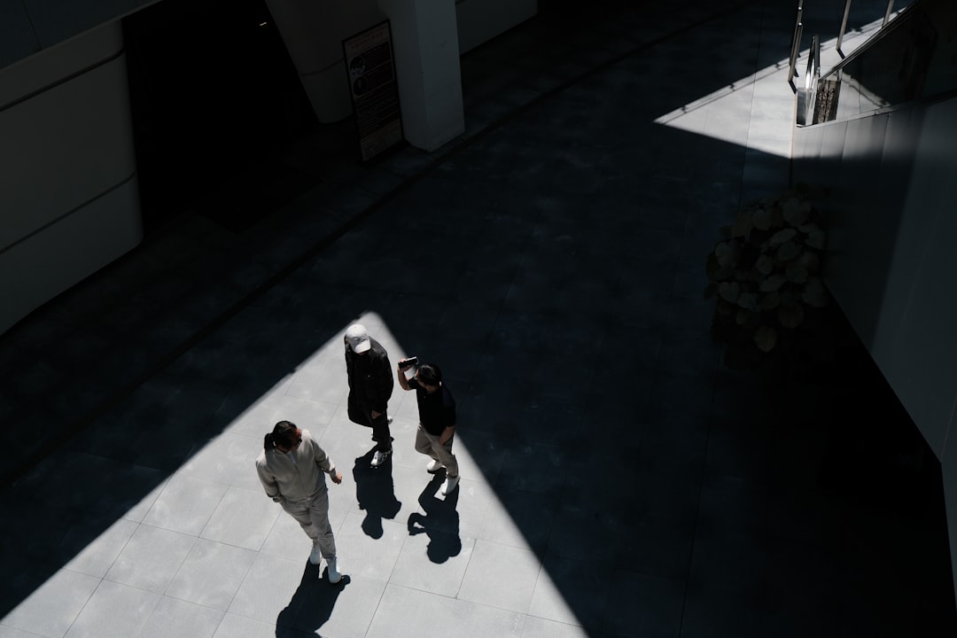 Three people walking in a sunlit, shadowed modern building. three dimensional mesh, autonomous robot, semantic mapping, indoor scene