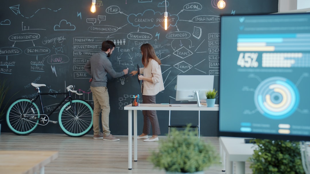 Two people collaborating on a chalkboard with a bicycle. business team virtual meeting secure connection lock icon digital interface