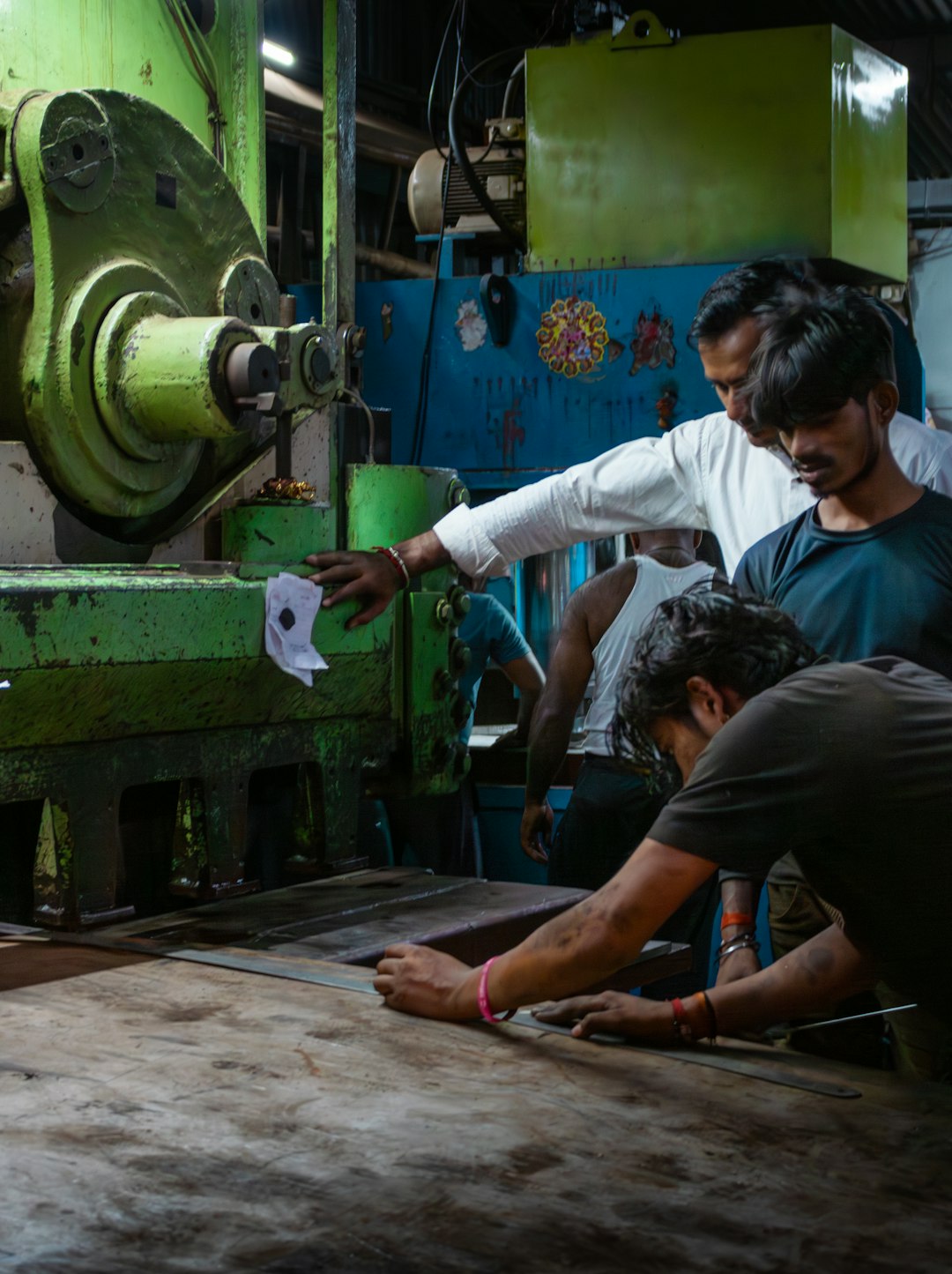 Workers operating heavy machinery in a factory. manufacturing floor, production planning, inventory software