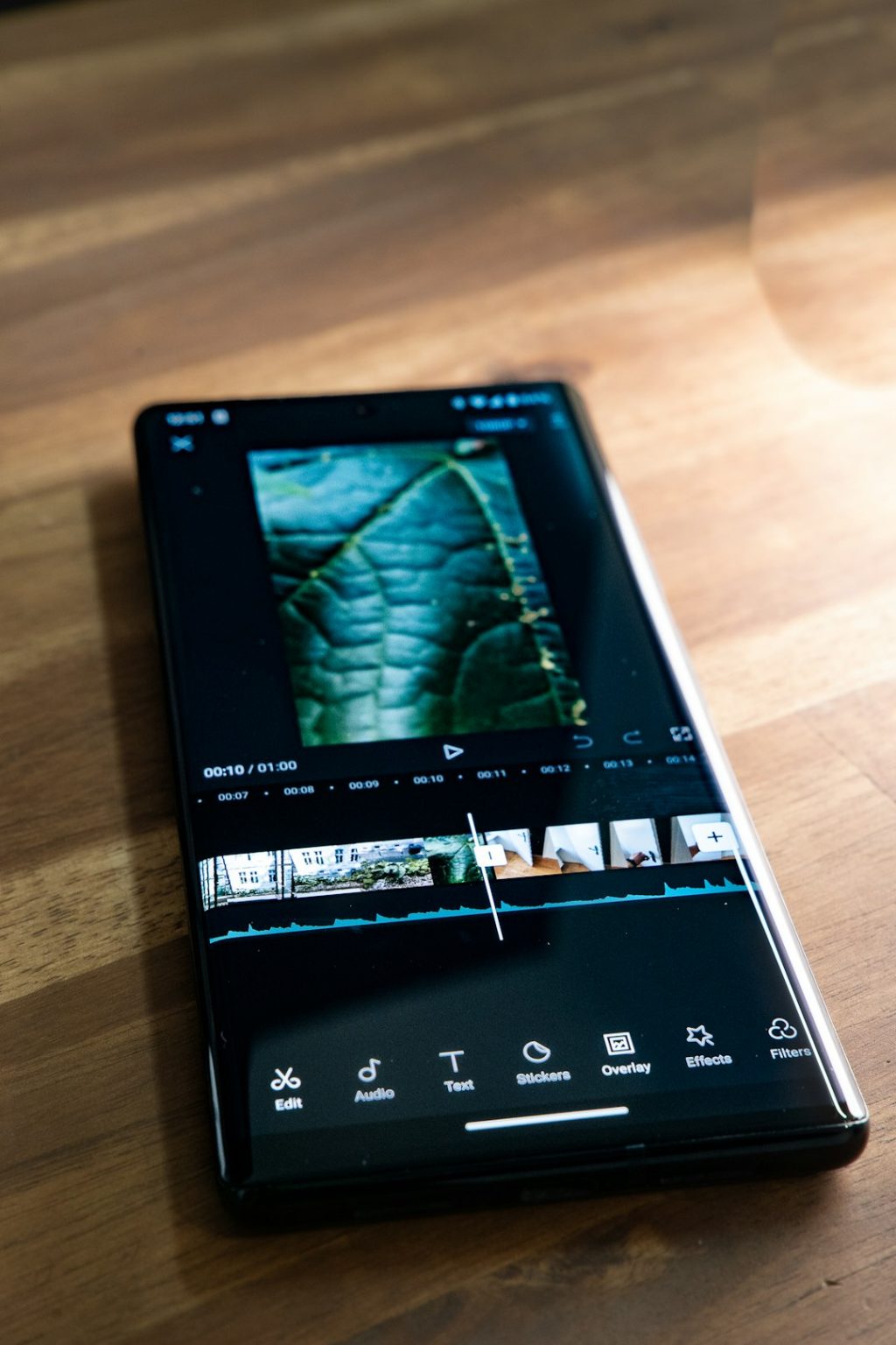 a black cell phone overlay clip split tool, CapCut timeline, spliced video layers
