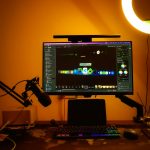 a computer monitor sitting on top of a desk live streaming gamer setup, colorful LED lights, streaming microphone and monitor