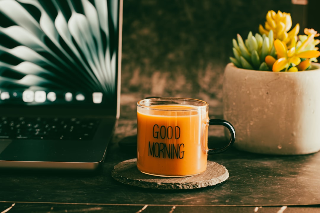 A glass mug with "good morning" text and a laptop. freelancer laptop coffee home office