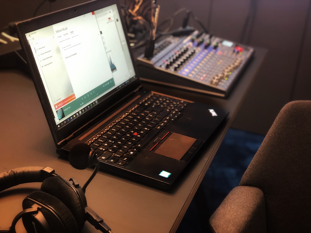 a laptop computer sitting on top of a desk music production studio laptop headphones audio editing screen