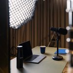 a laptop on a table professional streaming studio, camera microphone lighting, control desk, live broadcast environment