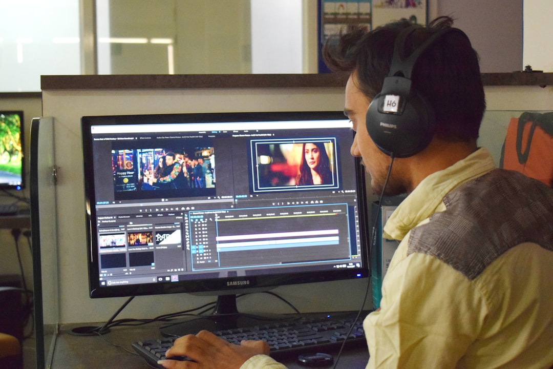 a man sitting in front of a computer with headphones on creative professional editing video, desktop editing software, cinematic footage on screen