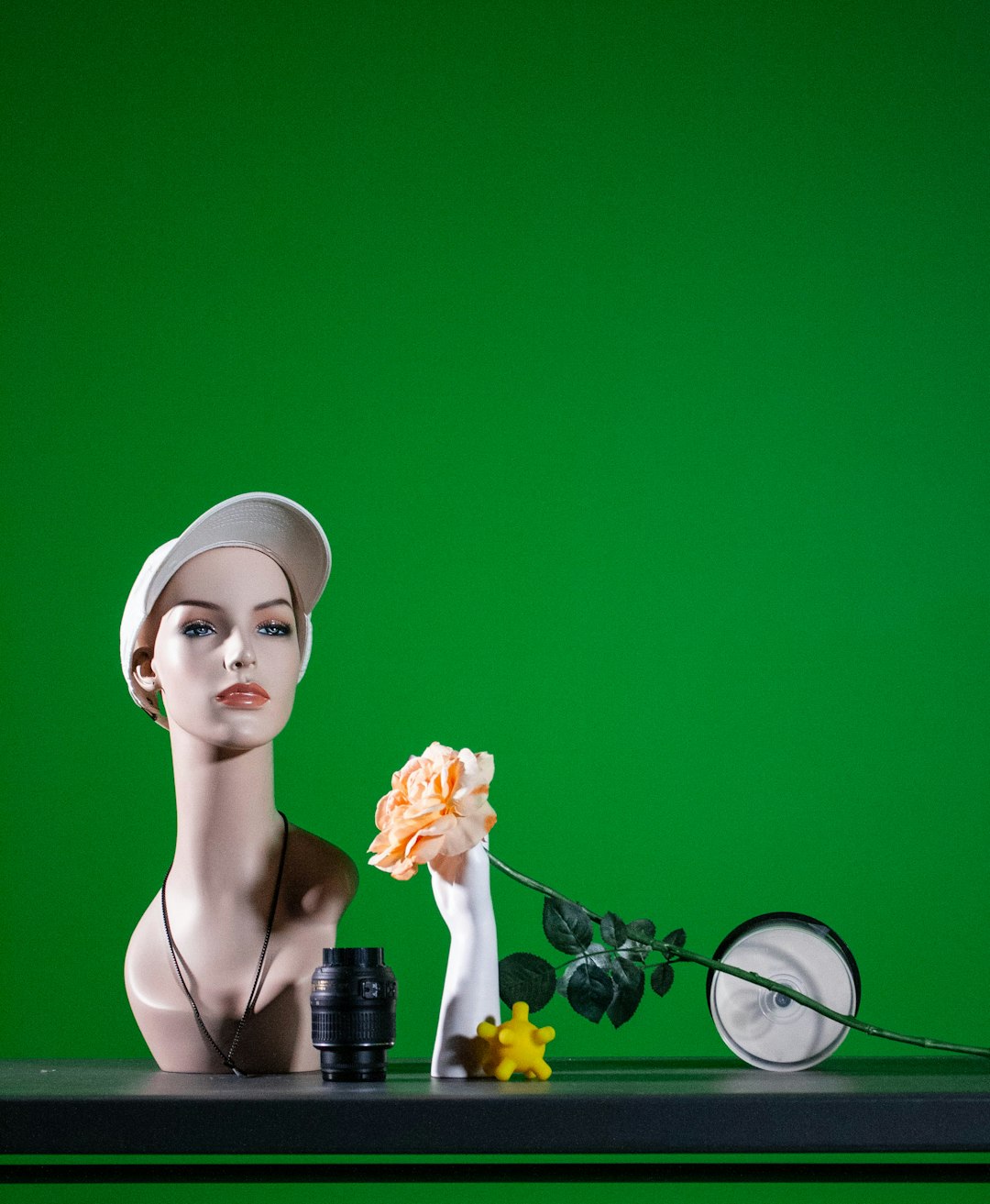 A mannequin sitting at a table with a vase of flowers product photography, background removal, ecommerce images