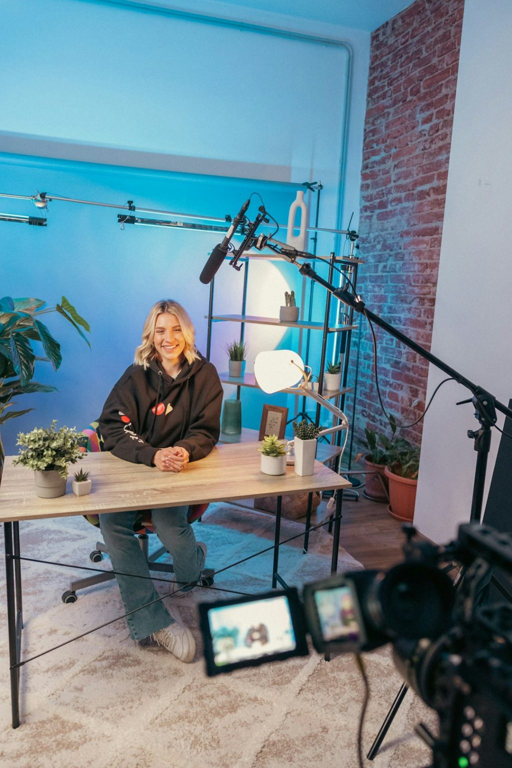 a person sitting at a table professional streaming studio, camera microphone lighting, control desk, live broadcast environment