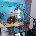 a person sitting at a table professional streaming studio, camera microphone lighting, control desk, live broadcast environment