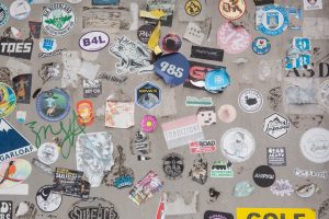 A wall covered in lots of different types of stickers custom stickers, product packaging, brand labels