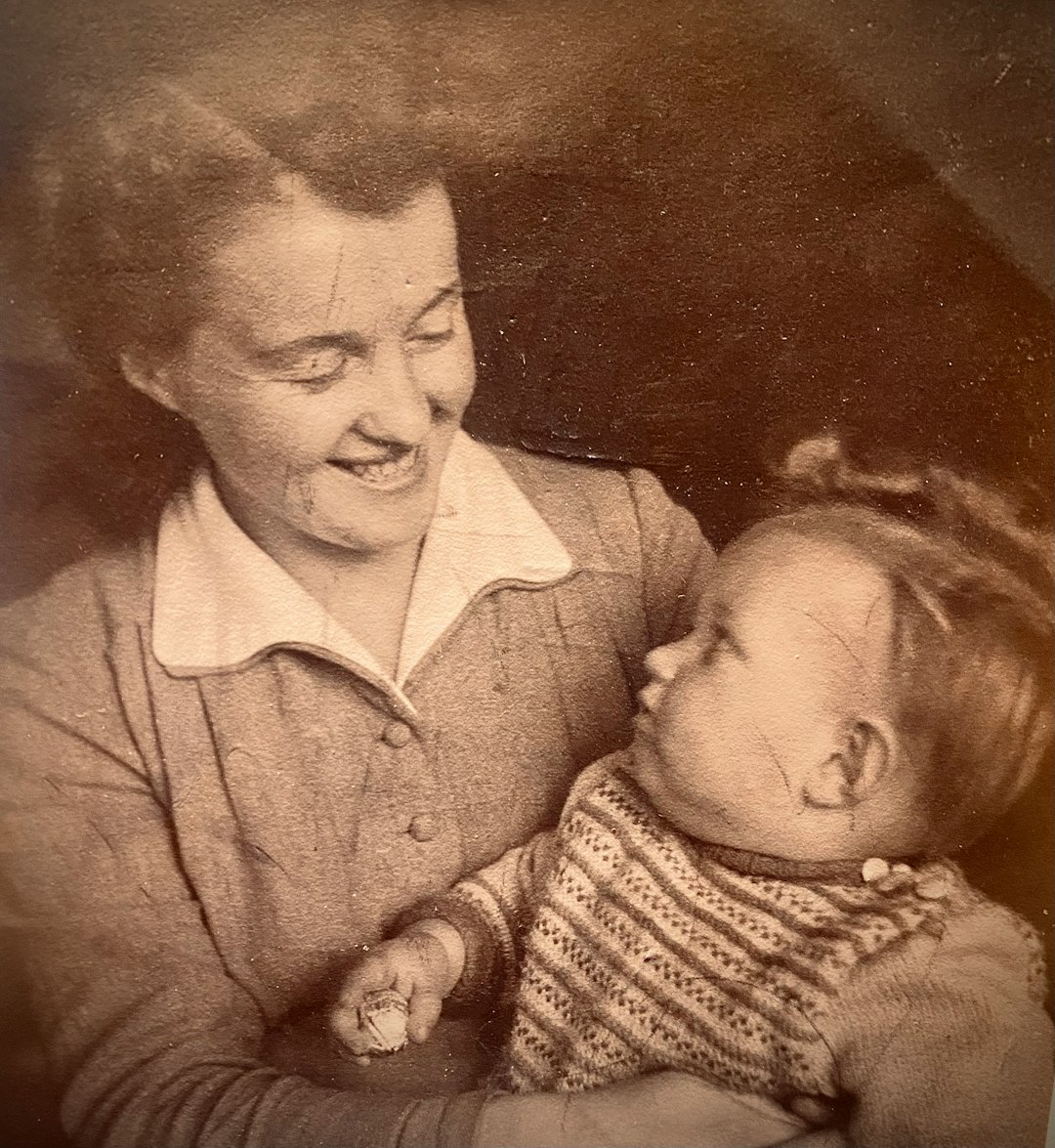 an old photo of a woman holding a baby old photo restoration, enhanced portrait detail, restored vintage photograph