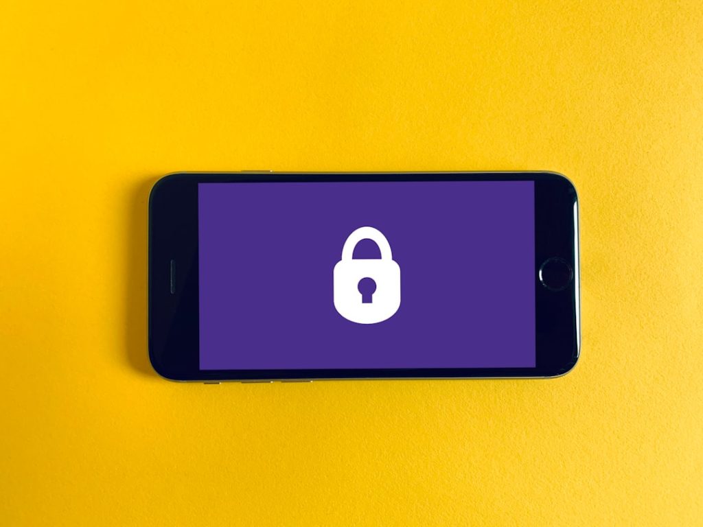 black iphone 5 on yellow textile encrypted messaging interface, smartphone secure chat, lock icon screen