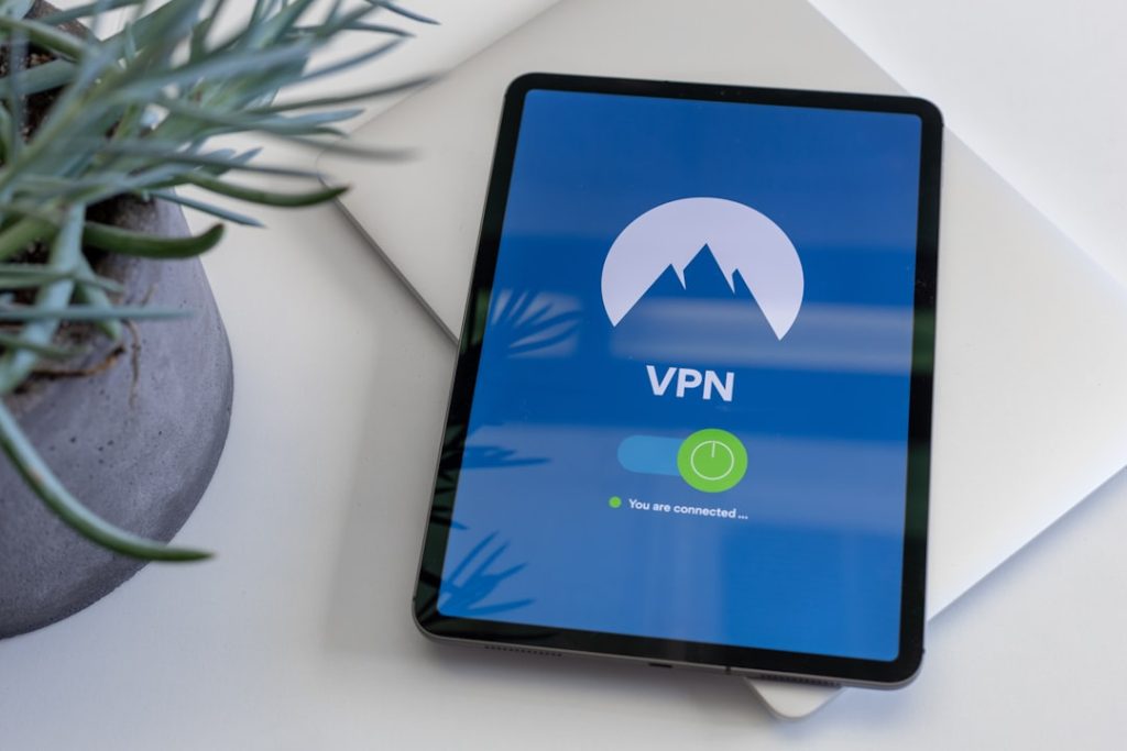 black tablet computer turned on displaying VPN encrypted connection illustration, global server network map, smartphone data protection
