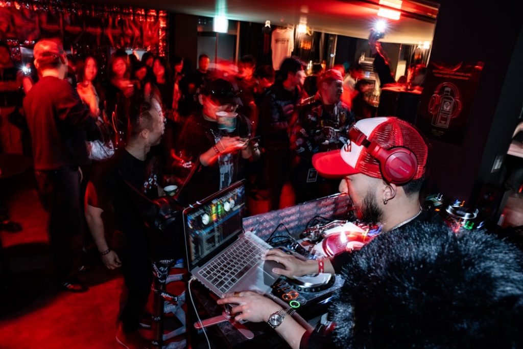 Dj playing music for a crowd at a party dj laptop performance, nightclub crowd, mixing software interface, colorful stage lights