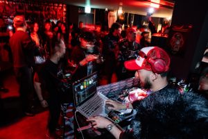 Dj playing music for a crowd at a party dj laptop performance, nightclub crowd, mixing software interface, colorful stage lights