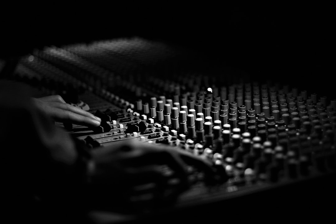grayscale photography of mixing console digital audio mixing console on screen, multitrack recording session, music producer working