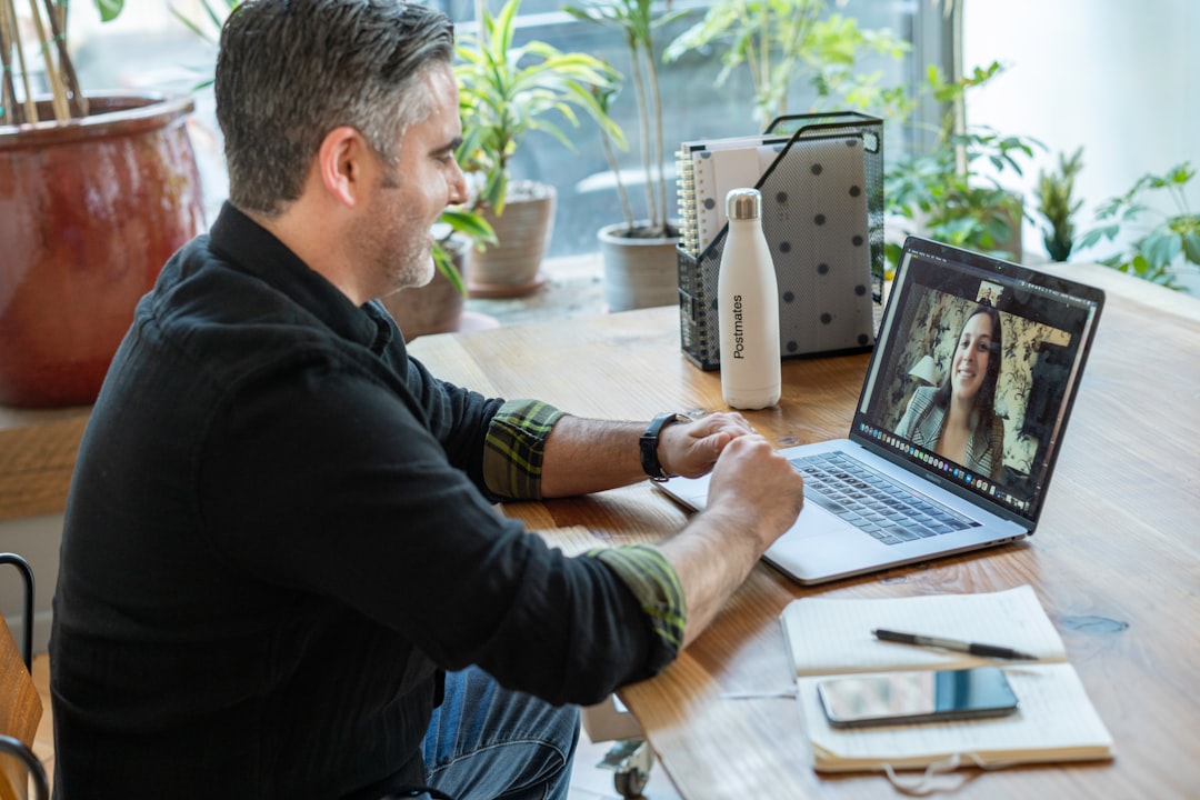 man in black sweater using macbook pro freelancer client meeting video call