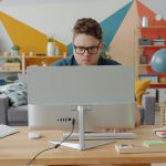 Man working on computer in colorful home office cloud security, remote workers, identity protection