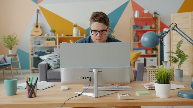 Man working on computer in colorful home office cloud security, remote workers, identity protection