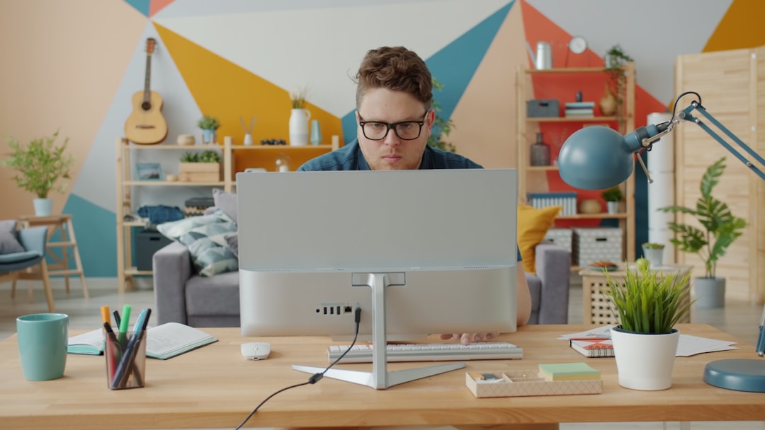 Man working on computer in colorful home office cloud security, remote workers, identity protection