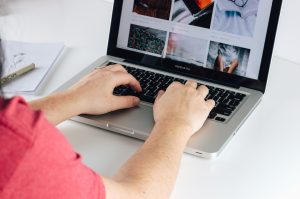 person using MacBook Pro plagiarism report screen, laptop writing desk, content editing software