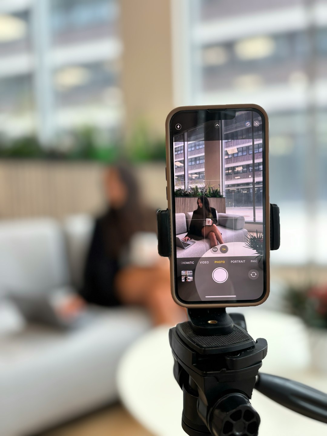 Smartphone recording a woman on a couch instagram reel analytics, watch time, shares, saves