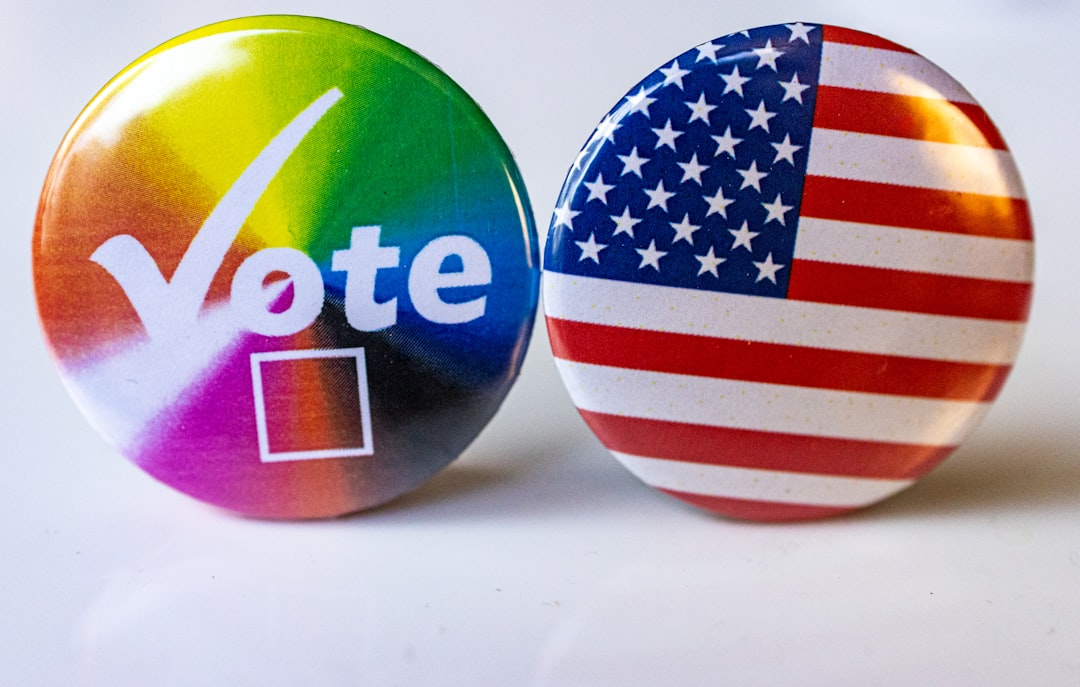 Two buttons with the words vote and the american flag election poll charts data graphs red blue states