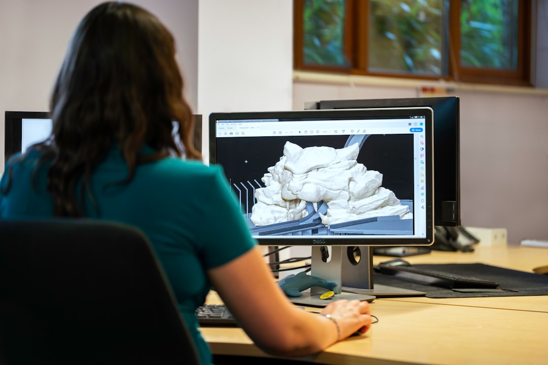 woman in blue t-shirt sitting at the table cad model, online quote, engineering workspace