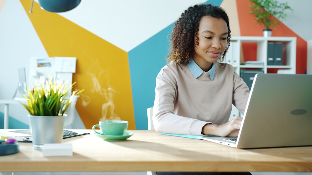 Young woman typing on laptop with coffee nearby freelancer laptop coffee home office