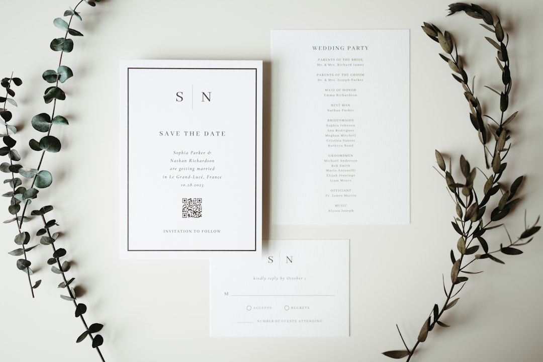 A couple of cards and some flowers on a table printed invitations, event stationery, professional flyer stack